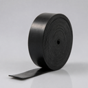 Coiled roll of thin black rubber strip standing on end, loose tail unwound across a pale grey backdrop