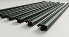 Five black side mouldings with green insert stripes laid out, studio shot
