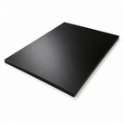Black acetal sheet angled on white, matt face with square-cut edges showing its thickness