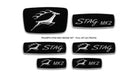 Flat lay of five black and silver Triumph Stag Mk2 badges including STAG MK2 scripts