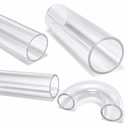 Close-up of large-bore clear acrylic tubes with cut ends, plus a U-shaped bend, on a white studio background.