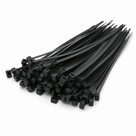 Pile of black nylon cable ties fanned out on a plain white background, ratchet heads facing forward