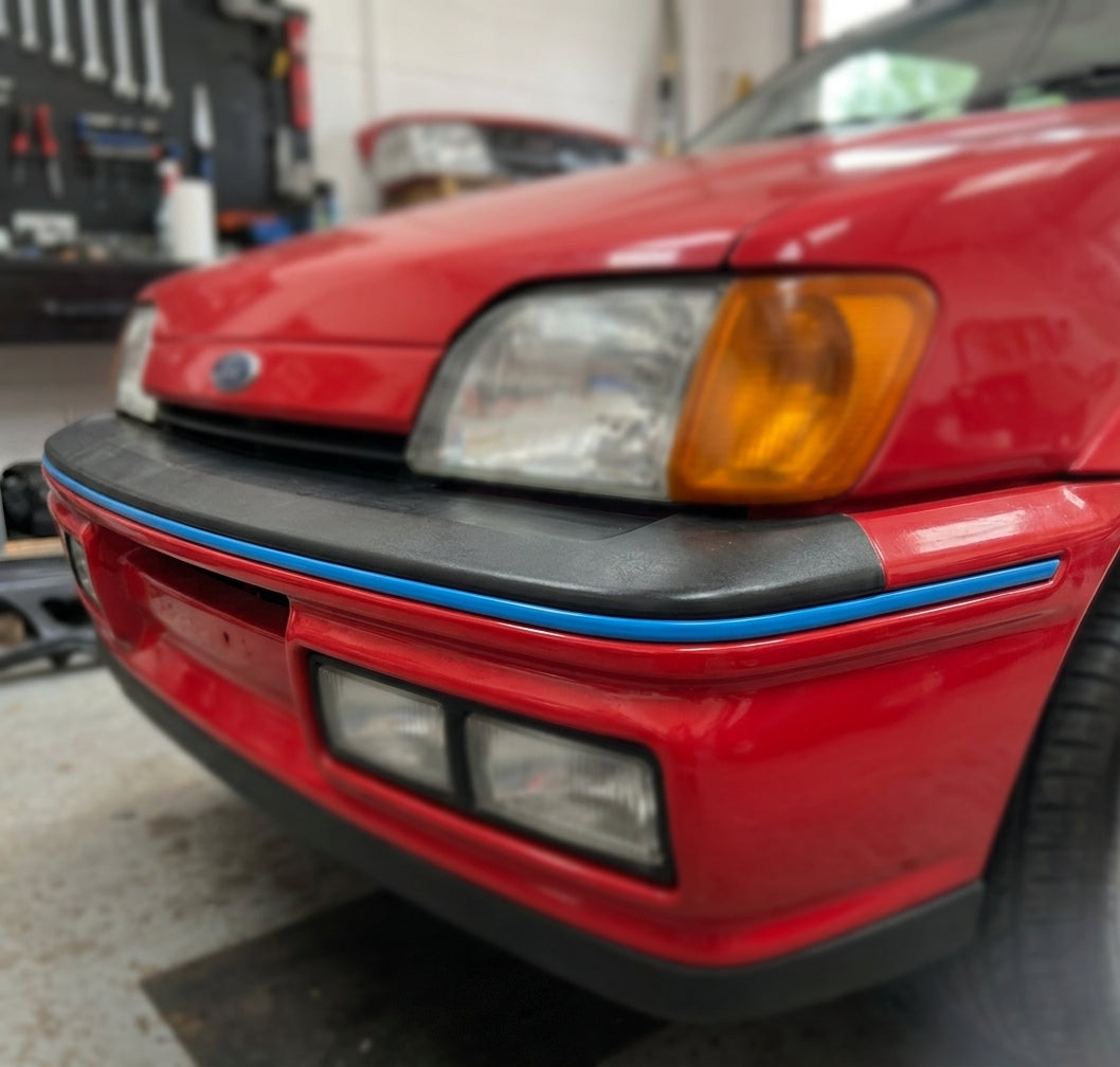 Blue trim strip fitted along a red Fiesta's front bumper edge