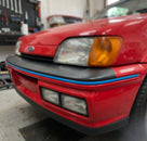Blue trim strip fitted along a red Fiesta's front bumper edge