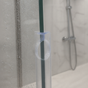 Close in-situ view of the clear oval-loop seal fitted to a glass shower edge, tiled wall behind.