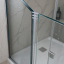 White seal in the vertical joint of a corner shower enclosure above a white tray