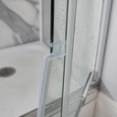 Clear seal fitted at a shower corner near the tray, marble-effect tiling behind.