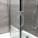 Clear oval-loop seal fitted midway up a glass shower door edge, shower tray below.