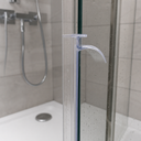 Clear triangle-and-loop seal fitted at a glass door edge, plant and bottle on the shelf behind.