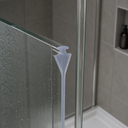 Clear seal fitted vertically along a shower door edge, shower head and hose visible.