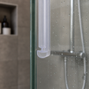 Clear T-seal fitted along a green-tinted glass shower door edge, near the mixer tap.