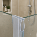 Clear oval-loop seal fitted at a glass shower corner, bathroom shelf and shower head behind.