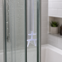 Clear H-profile seal outlined in blue, fitted at a glass shower corner near the shower head.
