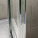 Close-up of the frame seal on a glass frame edge, tiled wall with water droplets behind