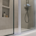 Clear seal fitted at the base of a shower door frame, close to the floor track.
