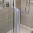 Clear hook-profile seal fitted at a glass shower corner above a bathtub.