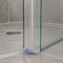 Clear seal with a lilac wave-shaped foot, fitted at the base of a shower door corner.