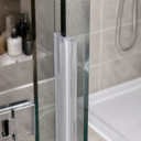 Clear twin-bulb seal fitted vertically along a glass panel edge, shelf with bottles behind.
