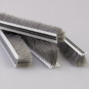 Four cut lengths of grey brush seal with clear T-shaped carrier strips on a pale grey background