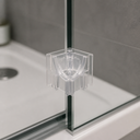 Clear plastic corner piece fitted to the vertical edge of a glass bath screen above a white shower tray