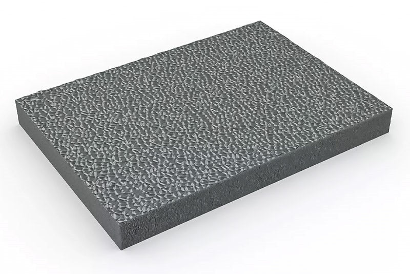 Grey anti-fatigue mat swatch shown at an angle, featuring a textured, pebbled, high-traction surface for slip resistance. The thick material is durable PVC foam designed for high-performance cushioning in workstations, industrial use, and under standing desks.
