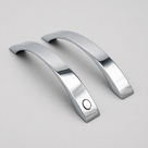 Matching pair of arched chrome shower handles on a pale background, polished tapered ends