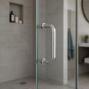 Polished chrome D-shaped pull handle fitted to a glass shower door in a grey tiled bathroom