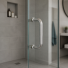 Polished chrome D-shaped pull handle fitted to a glass shower door in a grey tiled bathroom