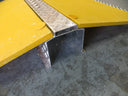 Close-up of the galvanised chequer-plate centre spine and triangular cable tunnel under the yellow wings