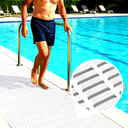 Barefoot man stepping from a pool onto white grid-textured matting, poolside loungers behind.