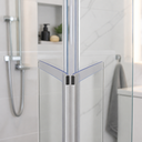 Seal fitted at angled glass corner join, chrome shower head and alcove behind