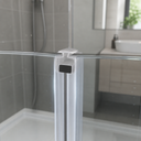 Paired white seal strips fitted at shower door join, tiled wall and plant behind