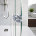 Clear M-shaped seal fitted at glass shower corner, chrome hose and plant behind