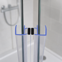 Clear seal fitted at glass shower door top, black magnets and tiled floor drain visible