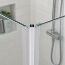 Clear V-seal fitted at glass corner, subway tile wall and chrome shower set behind