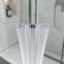 Blue-trimmed clear seal fitted at glass door join, alcove bottle and shower head behind