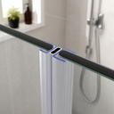 Black magnetic seal fitted between glass shower panels, marble tile wall behind