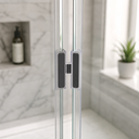 Black magnetic seal fitted between glass shower panels, marble tile wall behind