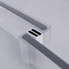 Two clear seal profiles gripping glass panel edges at a corner, black magnet strips at the meeting point