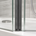 Seal fitted at glass shower screen corner, chrome shower head and hose behind