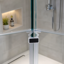 Clear seal with blue T-connector cap fitted at shower door corner, alcove behind