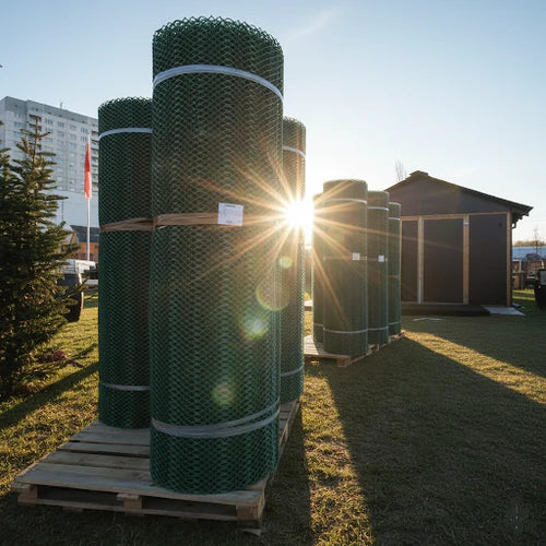 Stock of rolled green Grass Protection Mesh, demonstrating the large rolls of heavy-duty, 9mm thickness matting used to provide a non-slip surface for temporary event flooring.