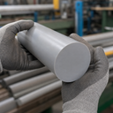 Mid-grey PVC rod held in grey gloves, smooth circular cut face forward, racked grey bar behind
