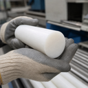 Glossy white polypropylene rod cradled in grey and cream gloves above racked white bar