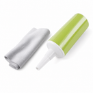 Green plastic applicator bottle with a white nozzle beside a folded grey microfibre cloth, on white.
