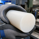 Thick natural white polyethylene rod gripped in blue and grey gloves, wide end face angled forward
