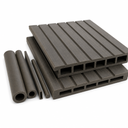 Two dark grey grooved boards with hollow rectangular chambers, beside round and square tube offcuts