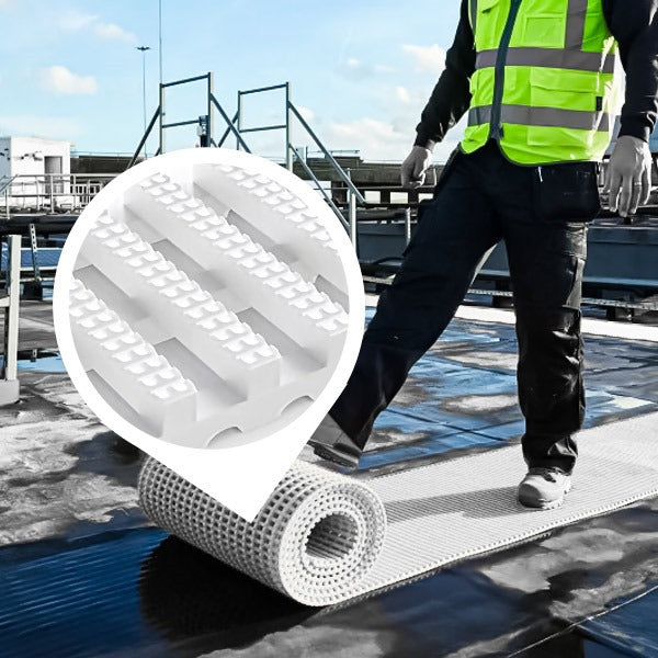 Temporary roll-out non-slip matting being installed for rooftop access. The light-colored plastic walkway is unrolled by a worker to create a safe, high-grip path for maintenance on a flat roof.