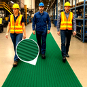 Three workers in hi-viz walk along a green ribbed PVC matting runway between factory production lines.