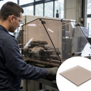 Worker at a machine enclosed by clear polycarbonate guards, inset bronze-tinted sheet corner